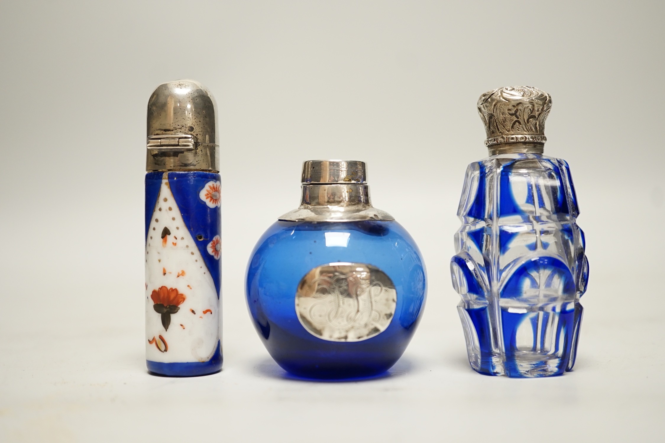 Three assorted silver or white metal mounted glass or porcelain scent bottles, tallest 78mm.